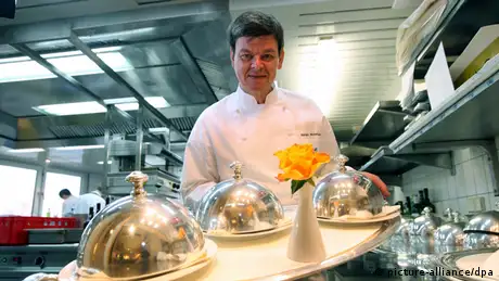 Drei-Sterne-Koch Harald Wohlfahrt posiert mit einem Tablett in der Küche des Restaurants Schwarzwaldstube des Hotels Traube Tonbach in Baiersbronn-Tonbach. Foto: dpa 