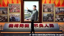 A man walks past a photo of Chinese President Xi Jinping at the Museum of the Communist Party of China in Beijing on March 3, 2023, ahead of the opening of the annual session of the National Peoples Congress on March 5. (Photo by GREG BAKER / AFP) (Photo by GREG BAKER/AFP via Getty Images)