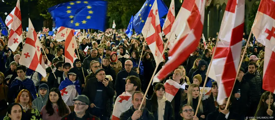 People hold Georgian and EU flags at a demonstration