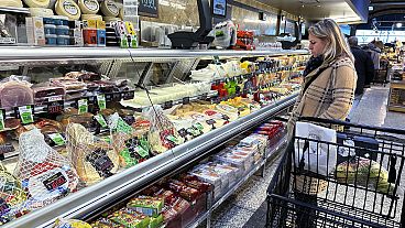 Eine Frau überprüft die Preise in einem Lebensmittelgeschäft in Wheeling, Illinois, am Freitag, 19. Januar 2024. 