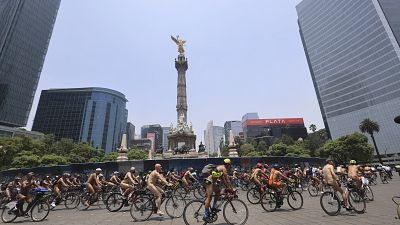 Cyclists pedal by the Angel of Independence monument marking World Naked Bike Ride day, in Mexico City