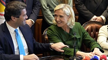 La líder ultraderechista francesa Marine Le Pen y André Ventura, líder del partido portugués Chega, a la izquierda, se miran durante una rueda de prensa en el Parlamento portugués.