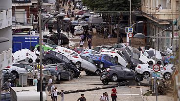 Varias personas caminan por una calle inundada en Valencia, España.