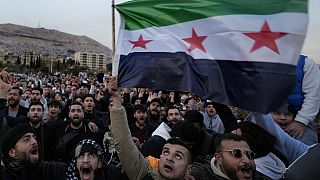 Syrische Bürger schwenken die Revolutionsflagge und rufen Slogans, während sie am zweiten Tag der Übernahme der Stadt durch die Aufständischen in Damaskus, Syrien, feiern, Montag