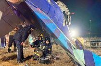 Nesta fotografia divulgada pelo Serviço de Imprensa do Ministério das Emergências do Cazaquistão, as equipas de salvamento trabalham nos destroços do Embraer 190 da Azerbaijan Airlines que se encontra no chão, perto do aeroporto.