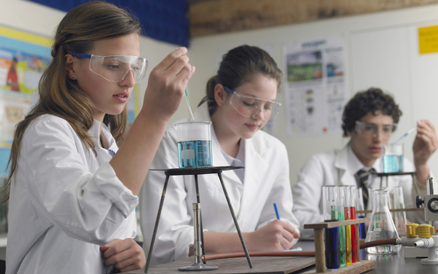 Estudantes realizando experimento em aula de Química