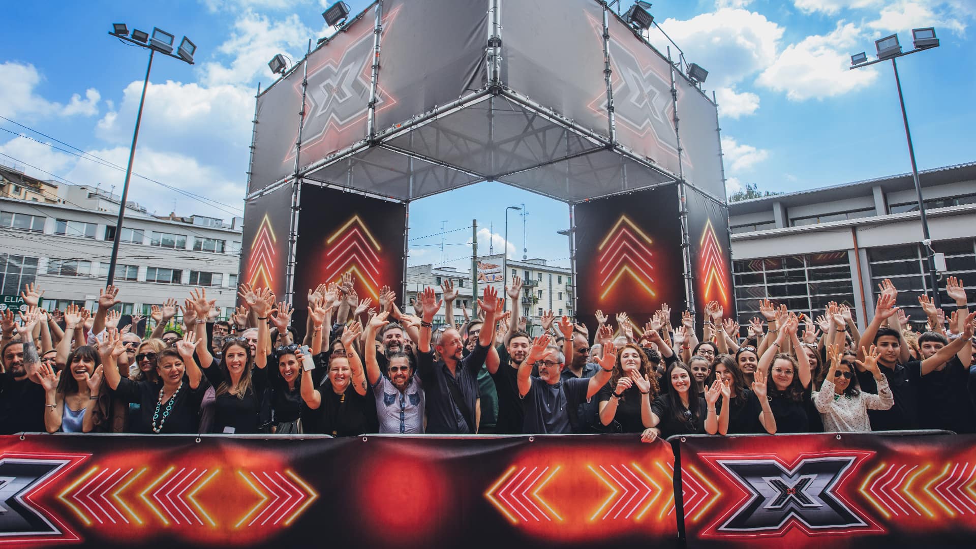 Una folla felice di persone aspetta di entrare come pubblico a X Factor 