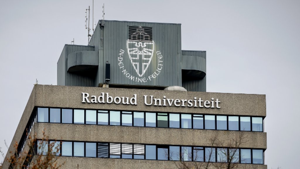 Het logo van de Radboud Universiteit te Nijmegen op een van de universiteitsgebouwen. De monnik en hoogleraar theologie Thomas Quartier wordt door een voormalige novice beschuldigd van grensoverschrijdend gedrag.