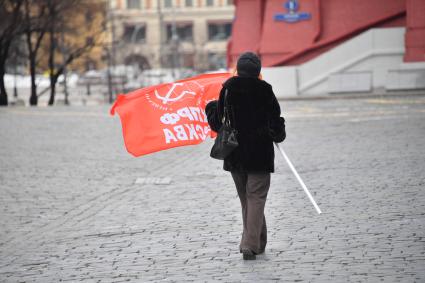 Москва.  Женщина с флагом после церемонии возложения венков и цветов к месту захоронения Иосифа Виссарионовича Сталина у Кремлевской стены.