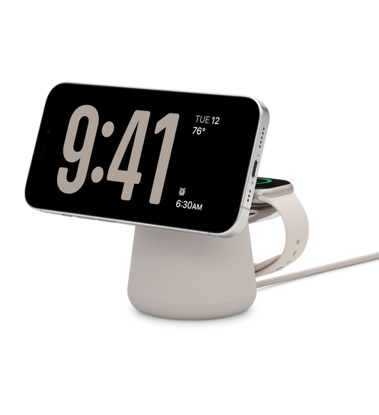 Belkin BOOST CHARGE PRO 二合一 MagSafe 無線充電座，橫向的 iPhone 正在充電，放於背面的 Apple Watch 亦在充電，充電座底部連接 USB-C 充電線