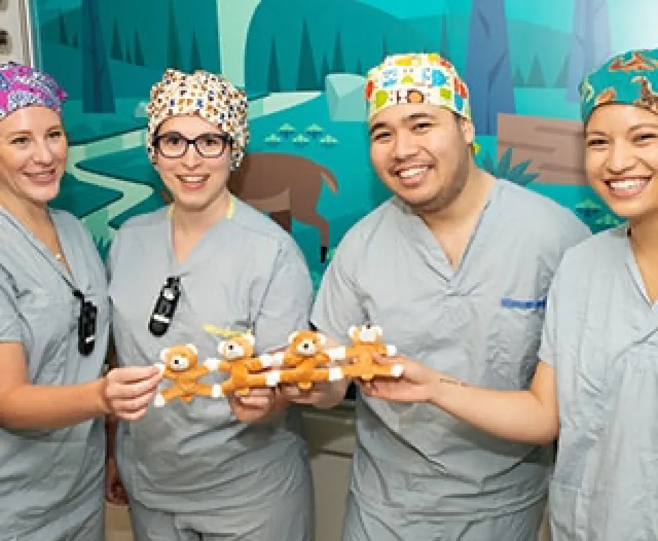 4 Nurses holding children's toys