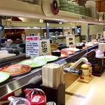 Genroku Zushi Noda Ten - 店内風景。「特殊詐欺に注意」なるカードも廻っていた。1種類のネタにつき1〜2皿単位で流していて、多品種対応という廻し方だ。