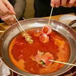 Niku Beji MEAT THE WORLD - “串鍋”に串を入れて加熱して食べる、の図。