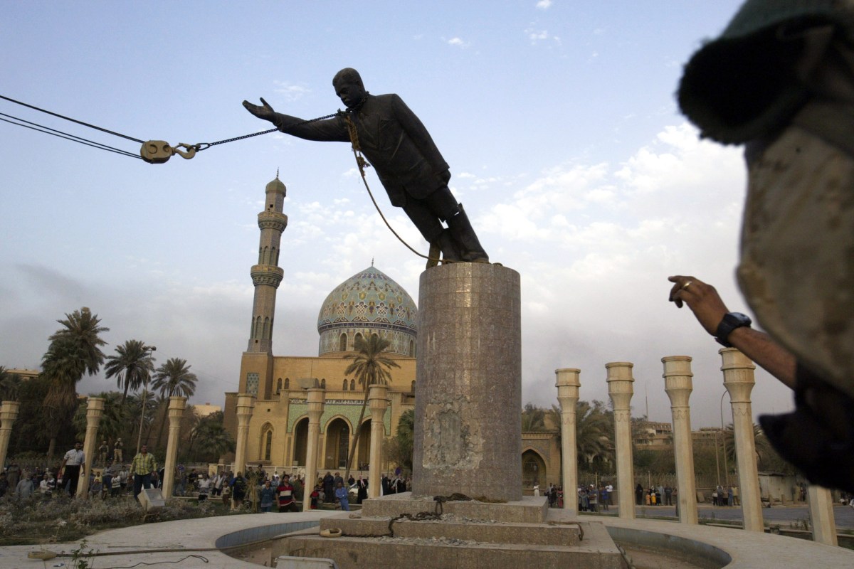 A U.S. marine watches a statue of Saddam Hussein being toppled in downtown Bagdhad Wednesday April 9, 2003. (AP Photo/Jerome Delay)