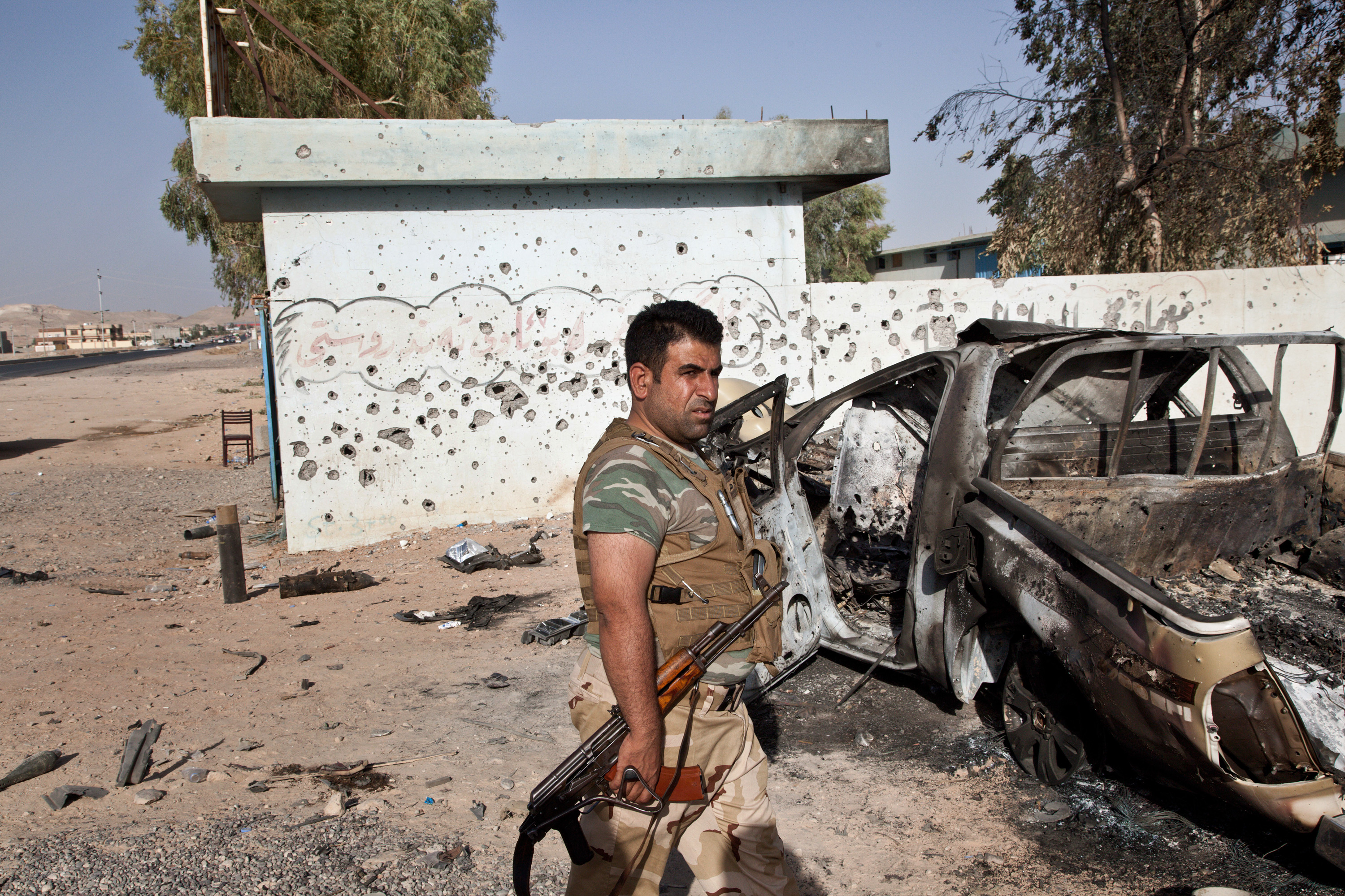 MAKHMOUR, IRAQ: A Kurdish peshmerga soldier walks past site where an ISIL position was hit during the fight between Kurdish and ISIL forces. After a series of American airstrikes across northern Iraq, the Peshmerga--the Iraqi Kurdish military--and the PKK--a guerrilla group fighting for pan Kurdish independence--retook the town of Makhmour from the Islamic State of Iraq and the Levant (ISIL) (Photo by Sebastian Meyer/Corbis via Getty Images)