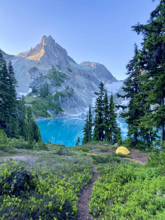 A beautiful view of Jade Lake with a yellow tent to stand out