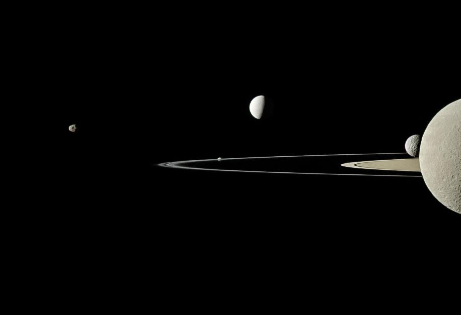 Cinc satèl·lits en una imatge de Cassini: Rea dividit en dos al primer pla de l'extrema dreta, Mimas darrere, Encèlad brillant per sobre i més enllà dels anells, Pandora eclipsada per l'anell F i Janus cap a l'esquerra.