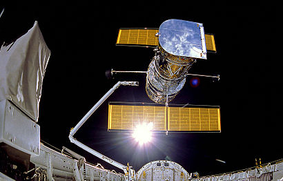 El telescopio espacial Hubble, equipado con paneles solares, es puesto en órbita desde la bodega del transbordador Discovery en 1990.