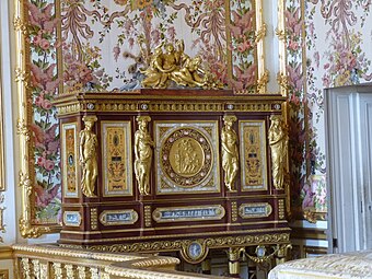 Louis XVI style caryatids with Ionic capitals on their heads, on a jewelry locket of Marie-Antoinette, by Ferdinand Schwerdfeger, 1787, mahogany, mother-of-pearl inlays, paintings under glass, porcelain plate, and gilded bronzes, Chambre de la Reine, Palace of Versailles, Versailles, France[12]