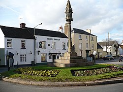 Restored mediaeval cross and Green Dragon Inn, St Thomas Square, Overmonnow