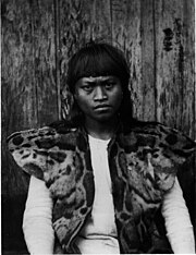 Photo en noir et blanc d'un jeune homme aborigène de Taïwan portant une veste en Panthère nébuleuse.