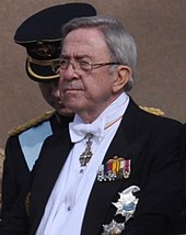 Photographie d'un homme âgé portant un costume avec de nombreuses décorations.