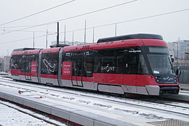 Vue d'une rame Rhônexpress, sous la neige, à l'arrêt.