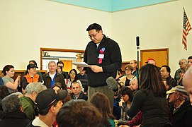 I'm not necessarily thrilled with the technical aspects of this 2016 photo of a Democratic Party caucus (the focus is on the people in the back; it really should be on the speaker), but Seattle's Museum of History and Industry used this photo in a spring 2021 exhibit that 'examines the continuing evolution of Washington State’s experiment in government “of, by, and for the people.”'