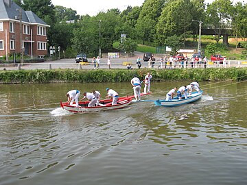 Het watersteekspel in Thuin. De boten worden naar elkaar toegetrokken met behulp van touwen.