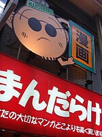 Signage for Mandarake Umeda in Osaka, depicting a cartoon image of Masuzo Furukawa.