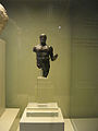 Estatuilla de bronce con incrustaciones de plata del Hércules Gaditano, como puede verse por las iniciales H. G. grabadas en la zona abdominal. Lleva en la mano izquierda las manzanas de las Hespérides. Época altoimperial romana, siglos I-II.