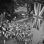 Cheering schoolchildren welcome the return of the British Army on 5 September 1945