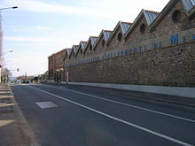 Façade sur rue de l’usine de la Sfim en pierre meulière.