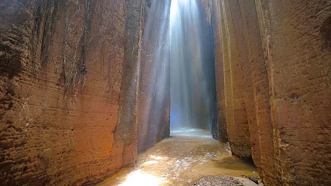 The Awhum Waterfall is located at Amaugwe village of Awhum town in Udi Local Government Area, Enugu State, Nigeria. The Awhum Waterfall is formed out of a massive outcrop of granite rock with water flow at the top forming a stream. Some part of the waterfall is usually warm through the seasons. Photograph: User:Nkwafilms