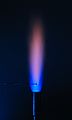 Flame test on sodium carbonate seen through cobalt glass