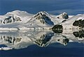 Glaciers and cliffs reflected in still waters at the south end of the channel.