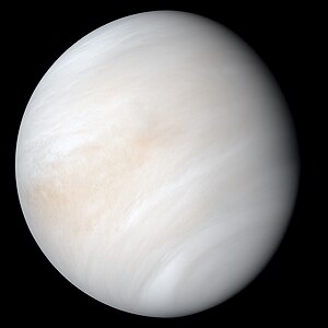 Venus in approximately true colour, a nearly uniform pale cream, although the image has been processed to bring out details.[1] The planet's disc is about three-quarters illuminated. Almost no variation or detail can be seen in the clouds.