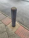 Wooden bollard painted grey, some paint is worn away