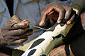 Un aborigine pinge un didjeridoo, un instrumento musical.