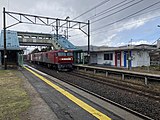 A freight train passing through a train station