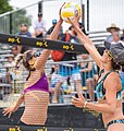 Image 9Two opposing players simultaneously contact the ball above the net with open hands, known as a "joust". The receiving team is entitled to another three contacts. (from Beach volleyball)