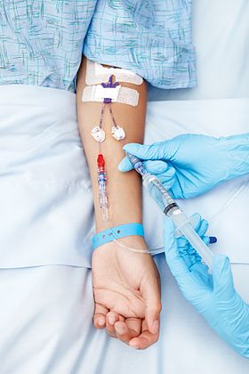 Photo of a person being administered fluid through an intravenous line or cannula（英語版） in the arm