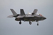 Вертикальна посадка F-35B, видно відхилене вниз сопло двигуна, позаду кабіни відкриті створки вентилятора