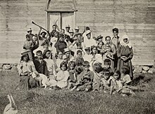 Photo de plus de vingt personnes devant un bâtiment typiquement Rapanui.