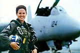 U.S. Navy Lt. Kara Hultgreen, la primera pilot de combat des d'un portaavions davant d'un caça Grumman F-14 Tomcat.