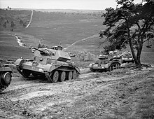 A tank in the foreground, followed by several others