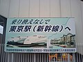 Penanda di Stasiun Sanuki pada Jalur Joban mempromosikan awal penyelesaian proyek. Tulisannya dibaca "Lansung, ke Stasiun Tokyo, ke Shinkansen"