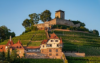 Vista do castelo Hohenbeilstein (acima), um castelo no topo de uma colina acima da cidade de Beilstein, no extremo sul do distrito de Heilbronn, em Baden-Württemberg, Alemanha. Suas origens estão no século XI; os componentes mais antigos ainda visíveis hoje datam do século XIII. Sitiado e destruído várias vezes, inclusive por fazendeiros rebeldes em 1525 e na Guerra dos Nove Anos (1688 a 1697) pelos franceses. O castelo hoje consiste de uma torre de menagem pentagonal de 28 metros de altura, que pode ser escalada como uma torre de observação, uma muralha de proteção de 2,5 metros de espessura e vários edifícios anexos na área do pátio externo, que agora são usados ​​como falcoaria e restaurante. O Unteres Schloss (abaixo) está localizado a meio caminho entre a vila e o castelo Hohenbeilstein. Ele consiste de um pátio construído no século XVI, no local do qual uma casa de campo foi construída entre 1906 e 1908 em estilo historicista para o industrial têxtil Robert Vollmöller. O Unteres Schloss é o centro de conferências da Igreja Evangélica em Württemberg desde 1957, que é proprietária do edifício desde 1959. (definição 7 487 × 4 736)