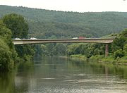 Blick vom Tanzwerder weserabwärts vom Weserstein auf dem Unteren Tanzwerder zur Weserbrücke; dahinter der Reinhardswald
