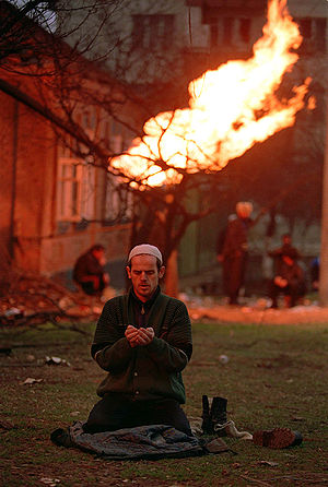 Chechen man praying during the war in 1995